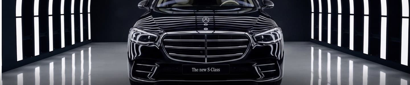 Front view of a black Mercedes S-Class in a streak-lit tunnel
